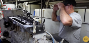 Technician visually inspecting a Cummins 6CTA engine