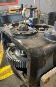 Technician uses a starrett dial indicator to measure the backlash between the gears on a Detroit Diesel engine.